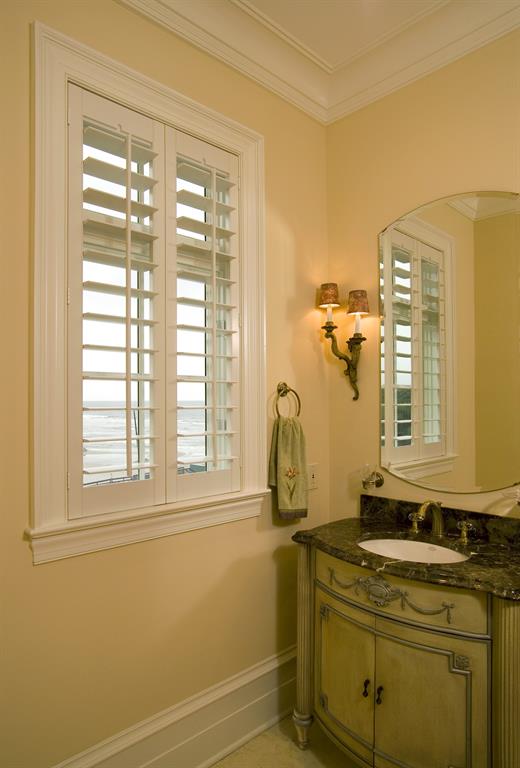 White shutters in a bathroom give a view of the ocean